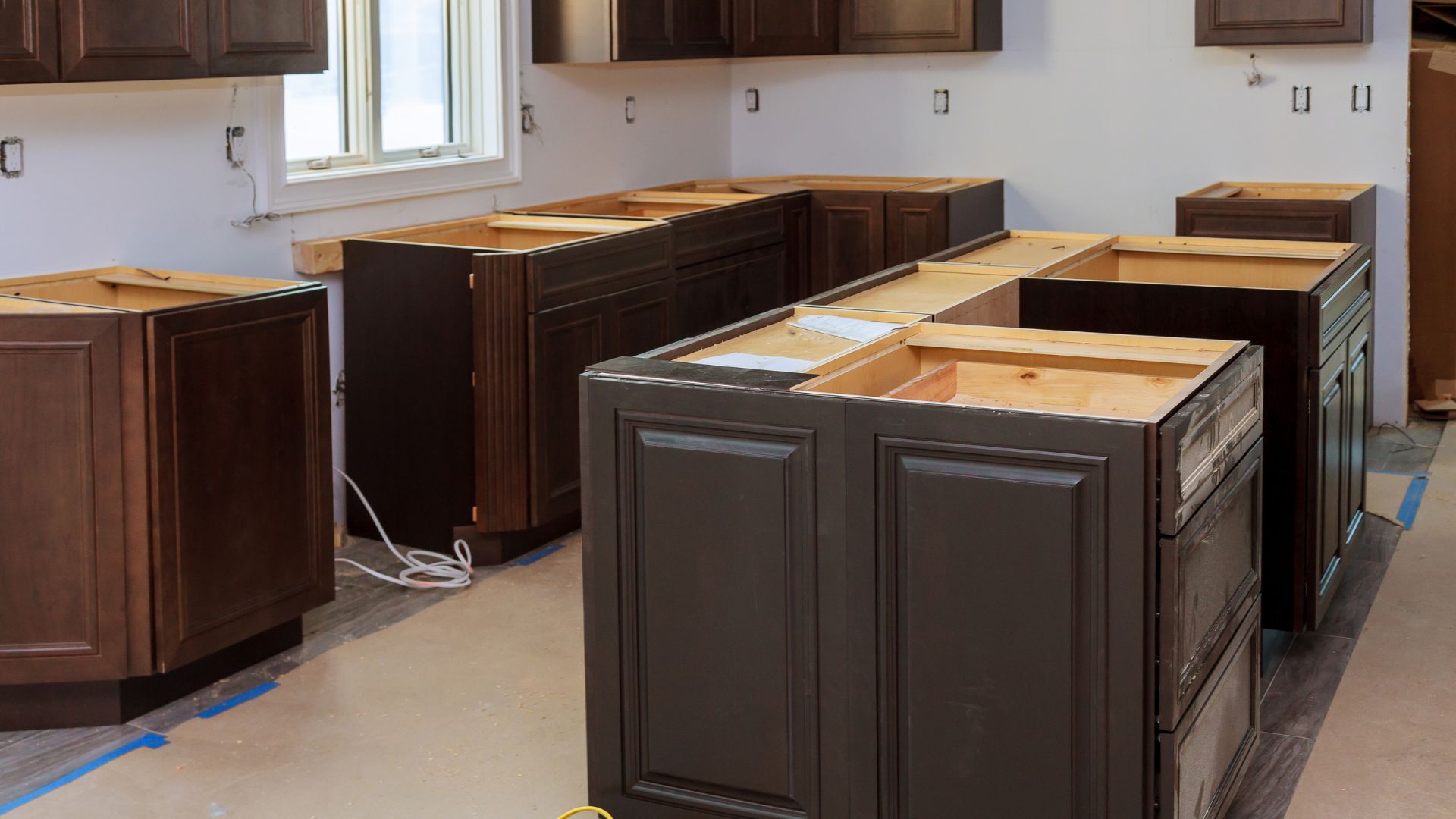 Kitchen renovation with dark wooden cabinets in various stages of installation