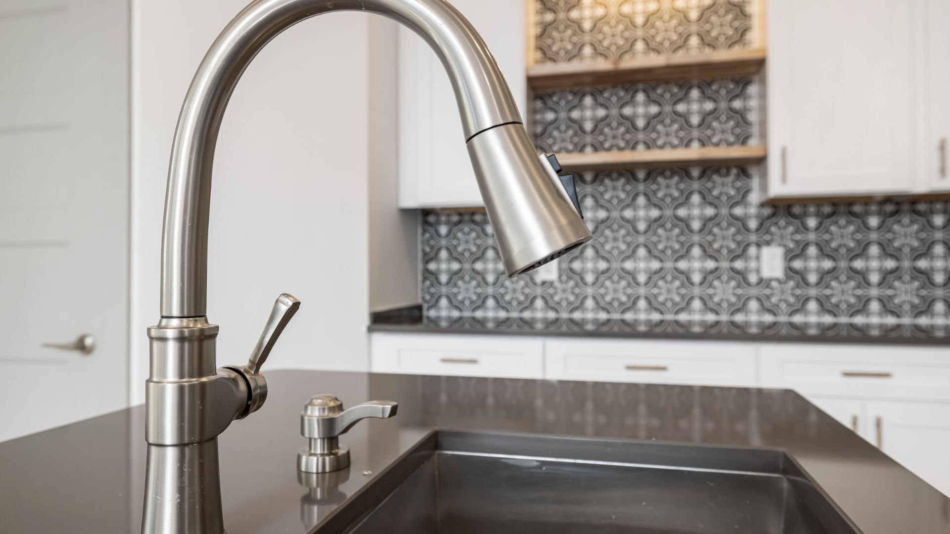 Modern kitchen sink with pull-down faucet and decorative backsplash tiles