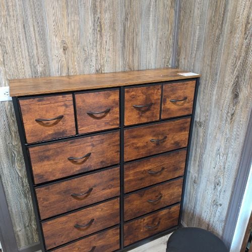 Rustic wooden dresser with multiple drawers against weathered wood paneling