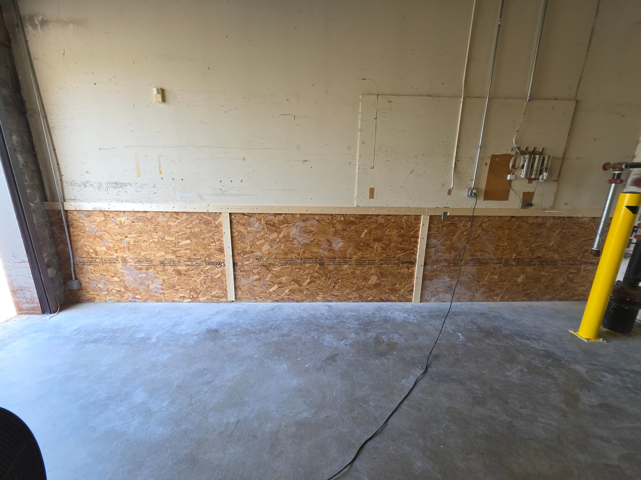 Unfinished interior wall with OSB boards and electrical outlets